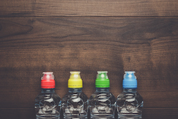 plastic water bottles with caps of different colour on the wooden table