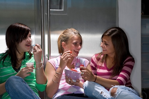 Teen girls laughing and eating