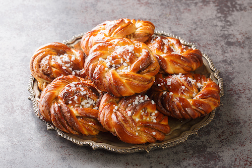 Homemade tasty Kanelbulle the nordic cinnamon rolls close-up on a plate on the table. Horizontal