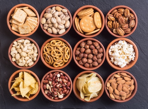 Mix of snacks : pretzels , crackers , chips , nuts and nachos
