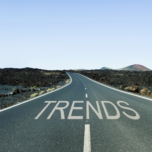 the word trends written in the asphalt of a lonely road with no traffic in a rural landscape